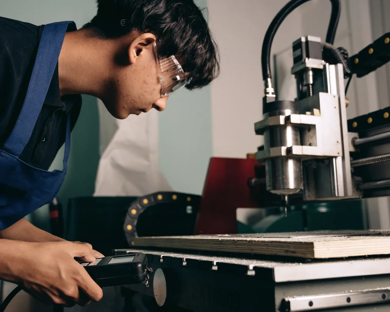 CNC engineer reviewing a machining process beside industrial equipment
